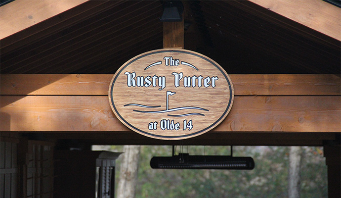 Golfers enjoying beverages beside the Rusty Putter cooler